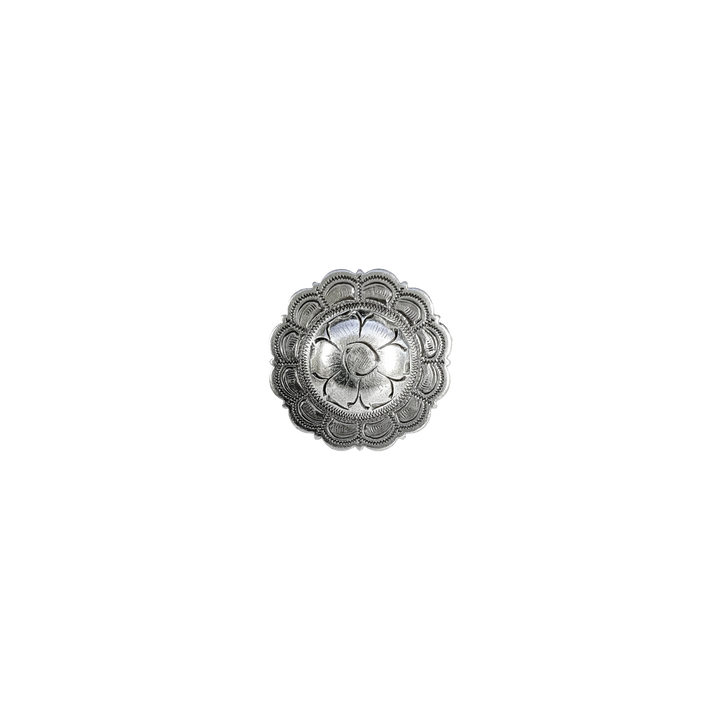 Decorative silver metal concho on a white background